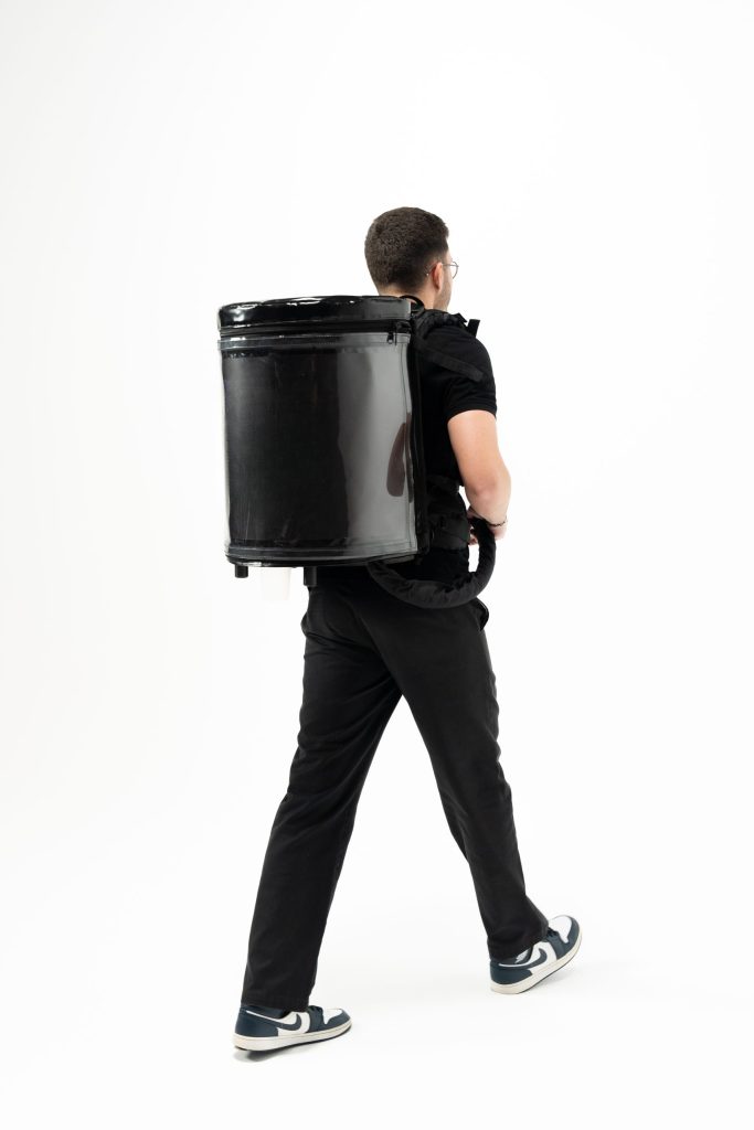 Back view of a server walking with the DraftGo backpack for soft drink or beer distribution.