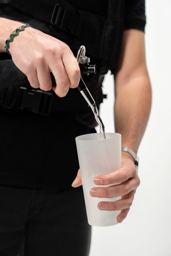 Close-up of DraftGo mobile beverage dispenser backpack pouring a carbonated drink into a cup